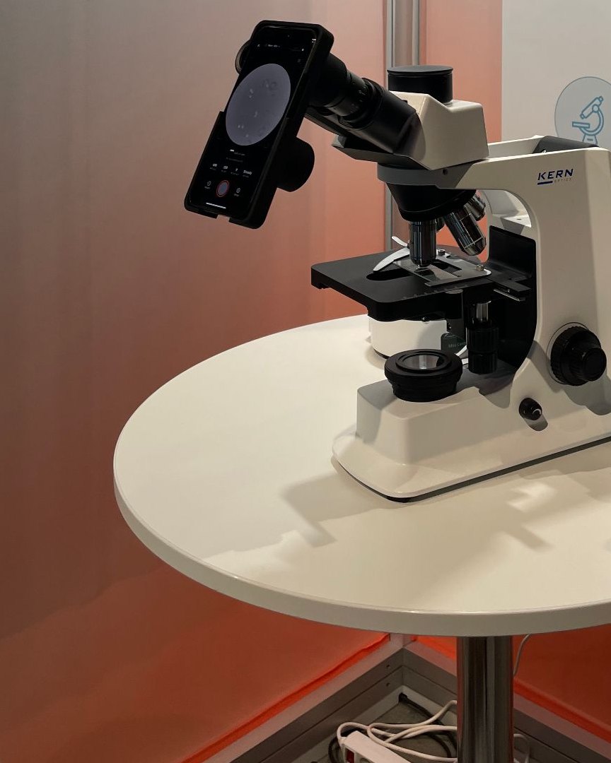An iPhone mounted on a precision adapter attached to a standard Kern light microscope
